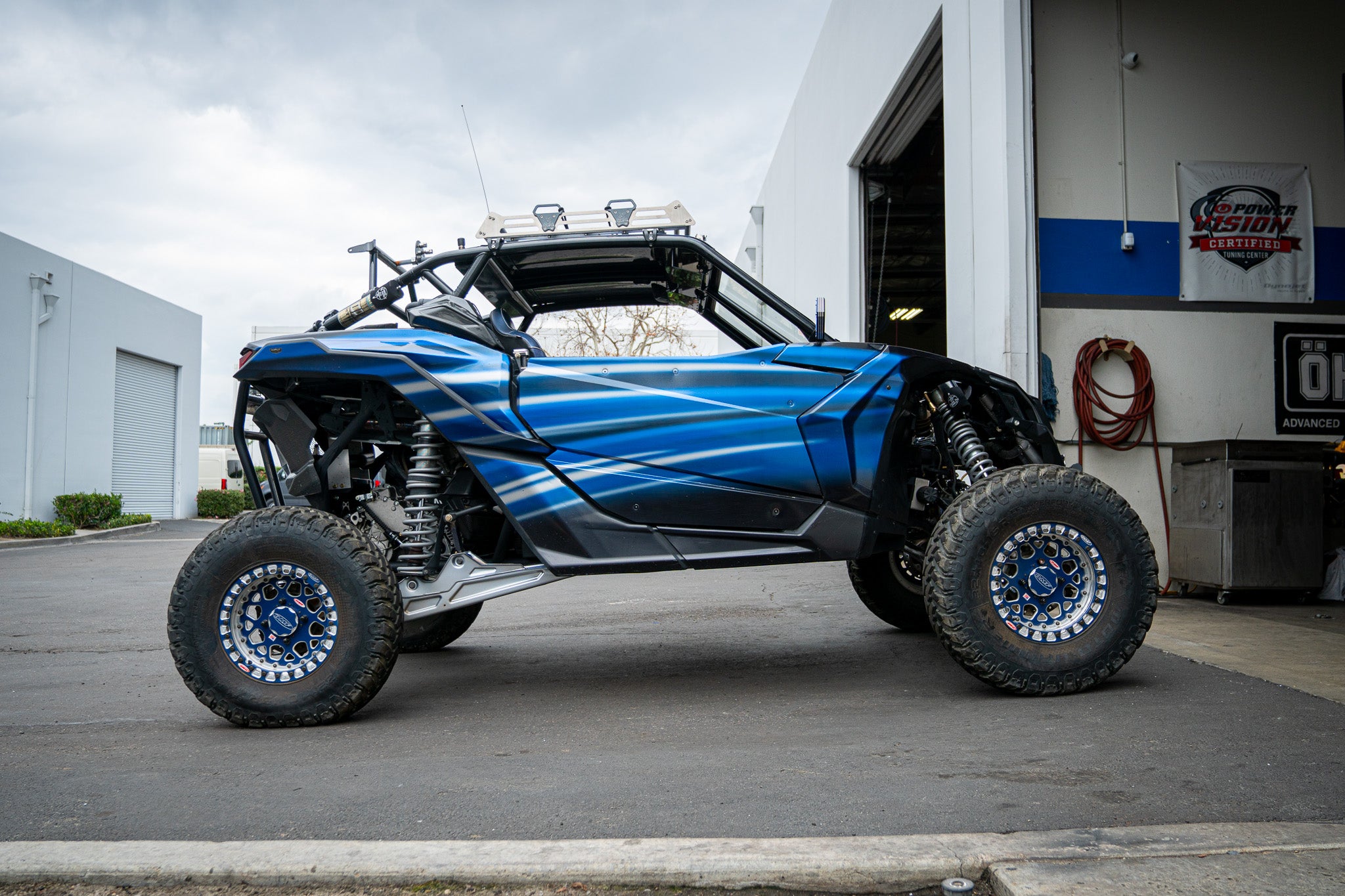 mickey cohen motorsports shop with garage open and off road vehicle parked outside